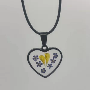 Heart-shaped epoxy resin necklace with real dried yellow and purple flowers on a black cord