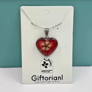 Zilverkleurige hartvormige ketting met bloem in rode hars.