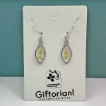 Zilverkleurige ovale oorbellen met witte bloem in hars.