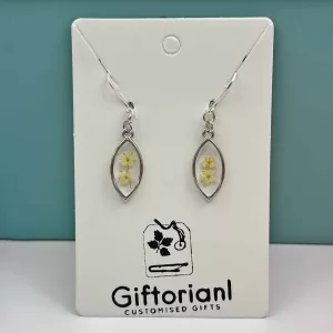 Zilverkleurige ovale oorbellen met witte bloem in hars.