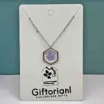 Zilverkleurige hexagon hanger met blauw vergeet-mij-nietje.