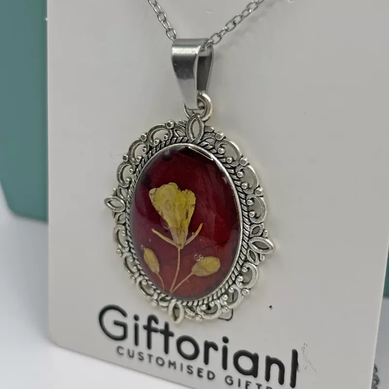 Handgemaakte droogbloemen ketting met rode epoxy hanger en roestvrijstalen ketting gedragen op de hals