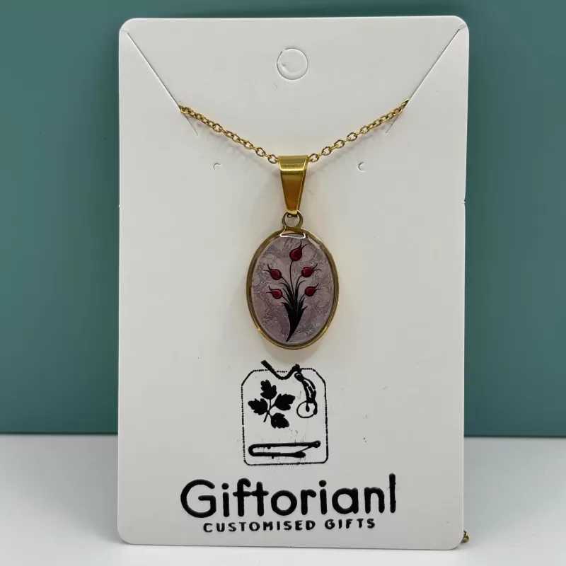 Handgemaakte tulpen ketting met ovale goudkleurige hanger en rood tulpdesign op witte kaart.