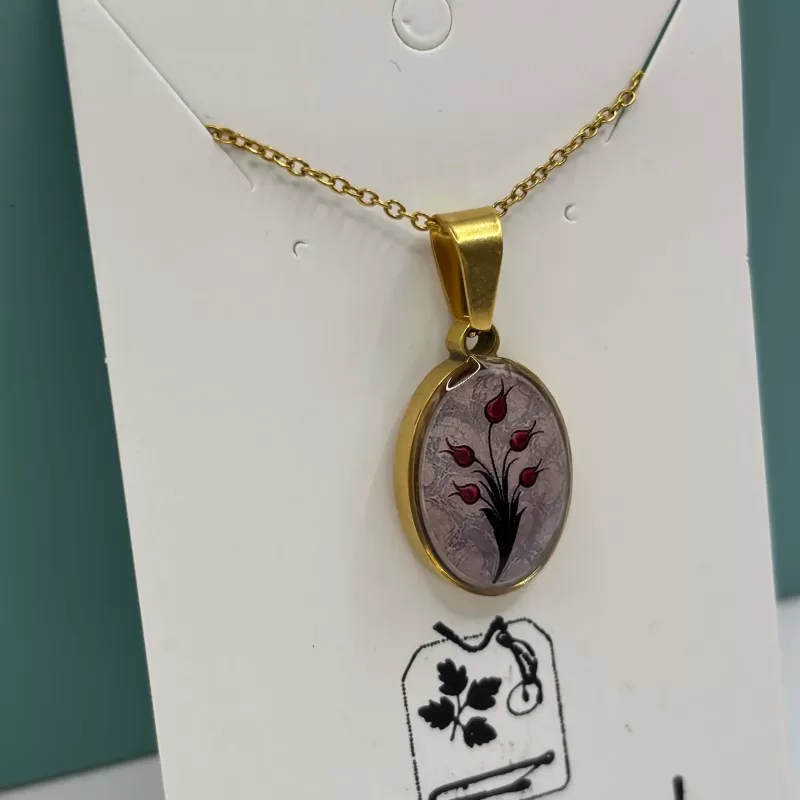 Handgemaakte tulpen ketting met ovale goudkleurige hanger gedragen rond de hals.